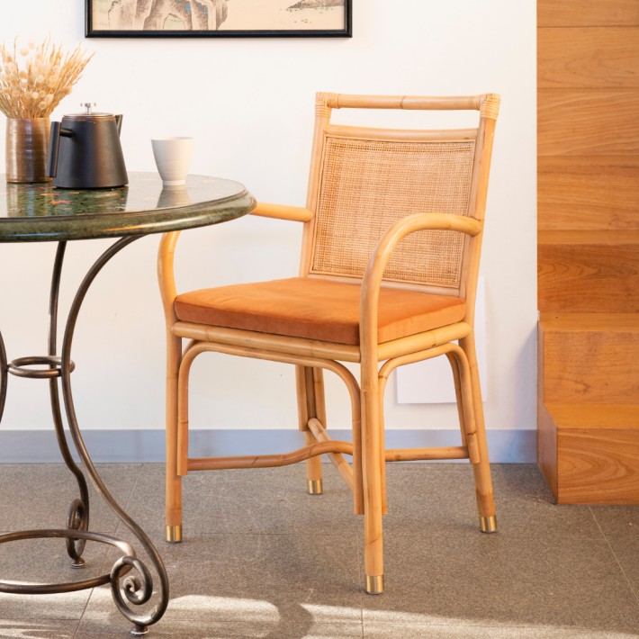 Ambiance fauteuil de table en rotin collection Riviera coussin velours ocre