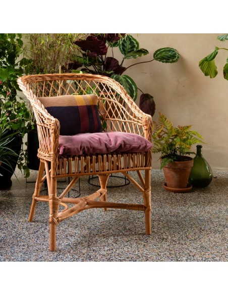 Fauteuil en osier ajouré Antonin en ambiance avec son coussin en velours en option
