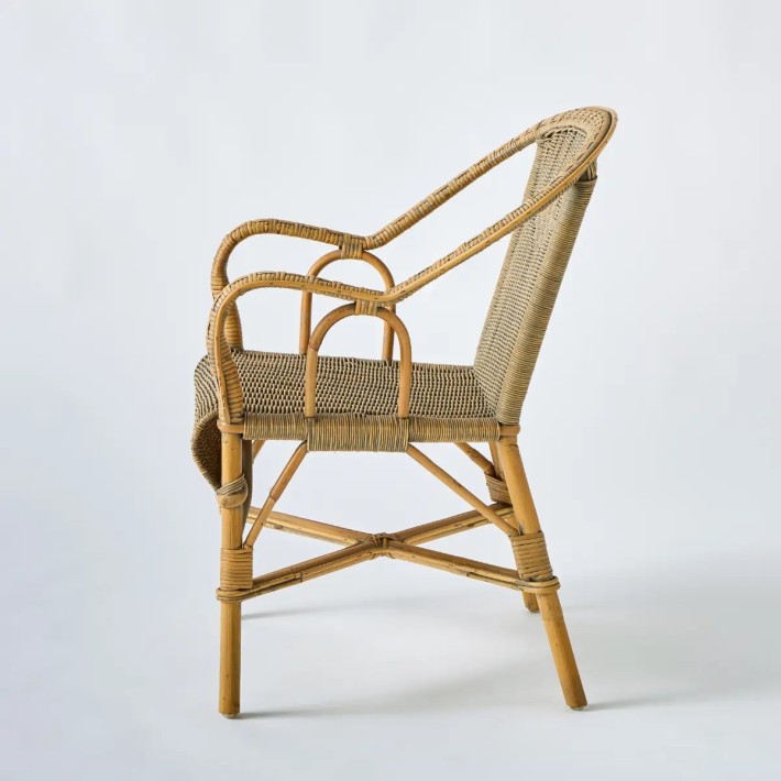 Side view of the Marcel armchair, a unique piece in woven rattan with a patina finish