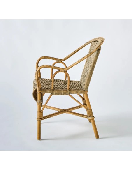 Side view of the Marcel armchair, a unique piece in woven rattan with a patina finish