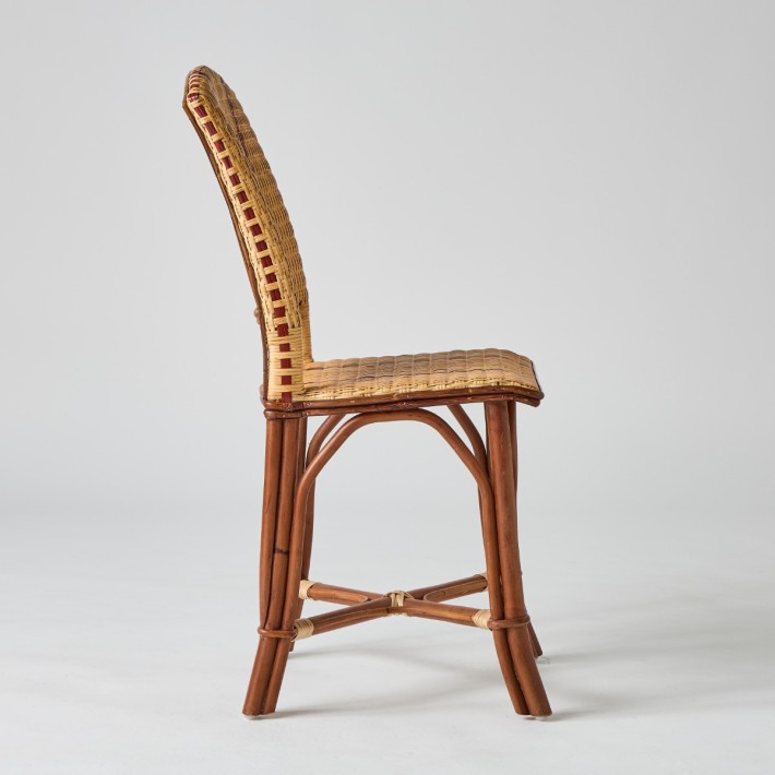 Vue de profil, chaise en rotin tressé avec liserés rouges collection Bagatelle