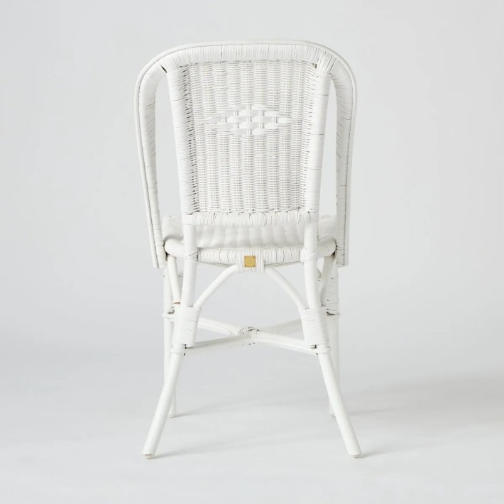 View of the back of a white lacquered woven rattan chair from the Primavera collection, available at KOK maison.