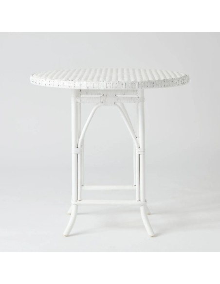 Front view of round table with white lacquered rattan woven top from the Primavera collection