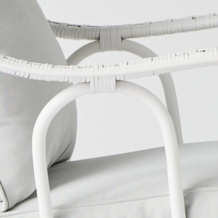Detail of the rattan weave on the armrest of the armchair from the Primavera collection in white lacquer at Kok Maison.