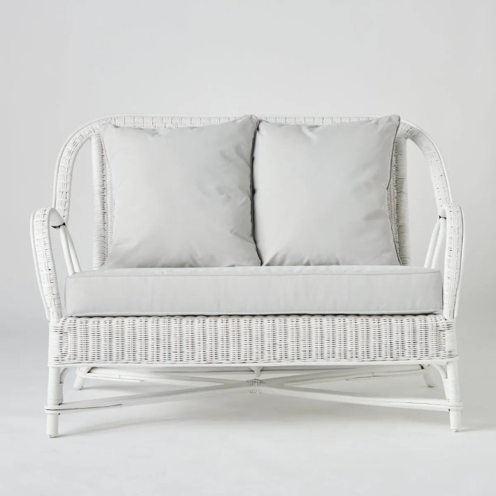 Front view of white lacquered rattan two-seater sofa from the Primavera collection by Kok Maison