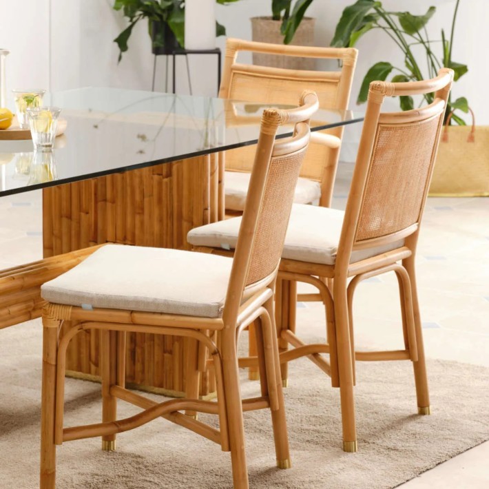 Indoor rattan chair with beige linen cushion. RIVIERA collection available at KOK MAISON.