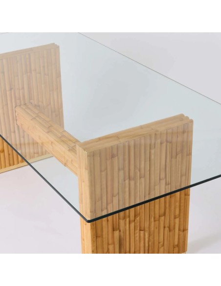Vue du pied en rotin par transparence avec le plateau en verre de la table de repas rectangulaire Riviera