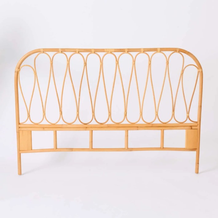 Front view of the Volute headboard, made entirely of rattan, at Kok Maison