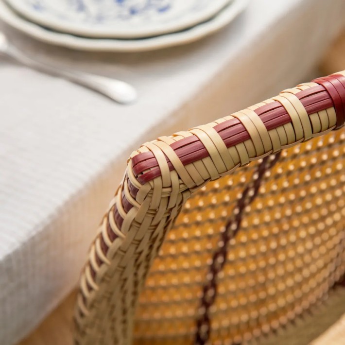 Close-up of the woven backrest on a resin chair with red netting – BELLE EPOQUE