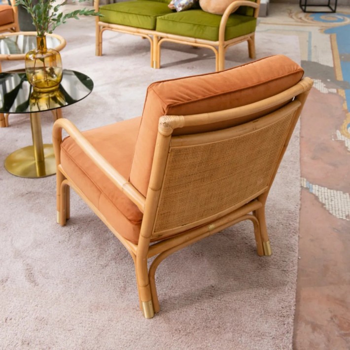 View of the rattan-woven backrest of an armchair from the RIVIERA collection, upholstered in ochre velvet